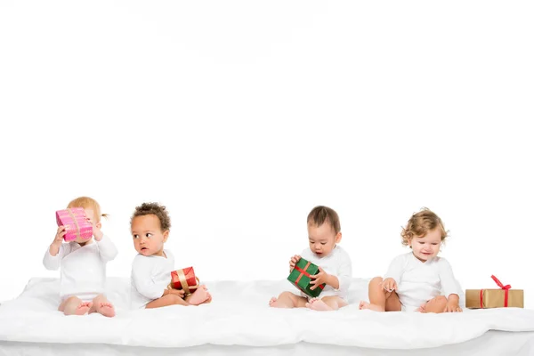 Multiethnic toddlers with wrapped gifts — Stock Photo