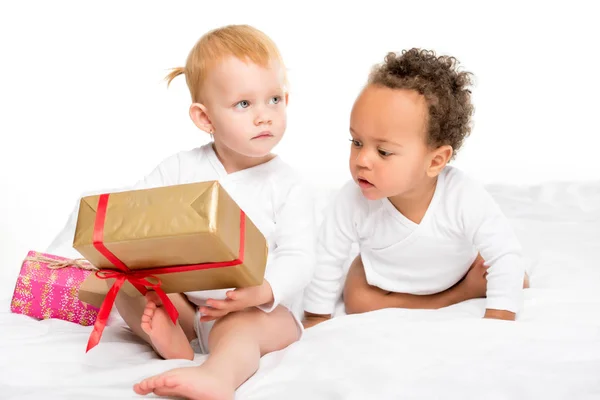 Multiethnic toddlers with wrapped gifts — Stock Photo