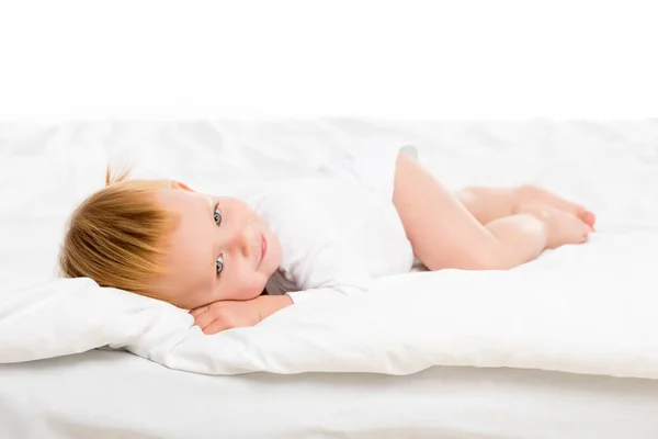 Bambino sdraiato sul letto — Foto stock