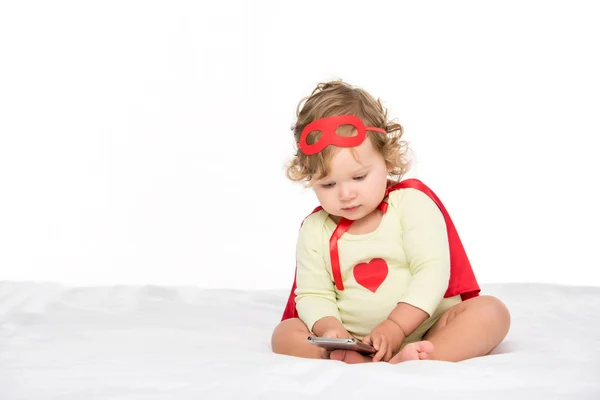 Bambino in costume da supereroe con smartphone — Foto stock