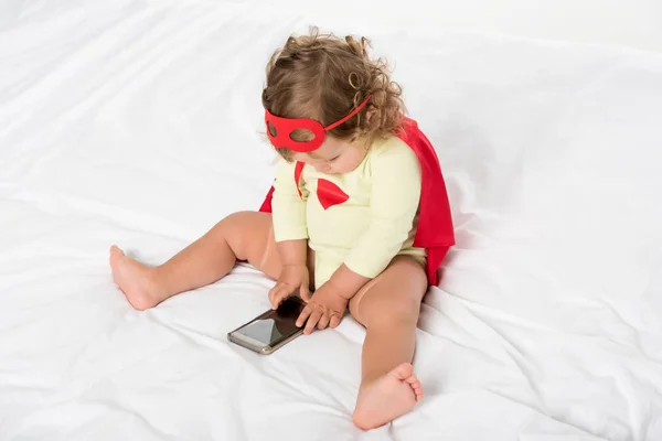 Малюк в костюмі супергероя зі смартфоном — стокове фото
