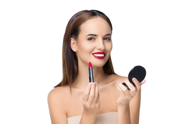 Jeune femme appliquant le maquillage — Photo de stock