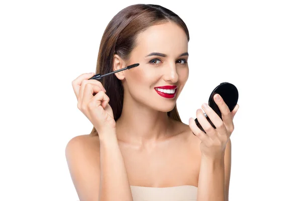 Jeune femme appliquant le maquillage — Photo de stock