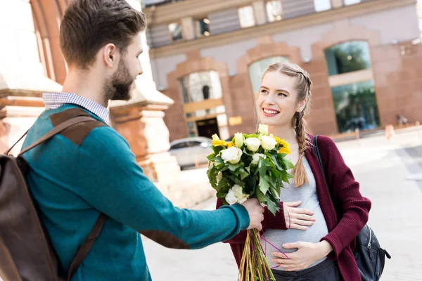 Uomo che presenta fiori alla moglie — Foto stock