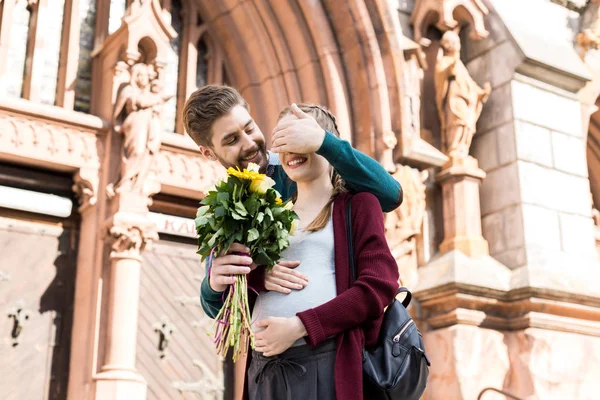 Man surprising wife with flowers — Stock Photo