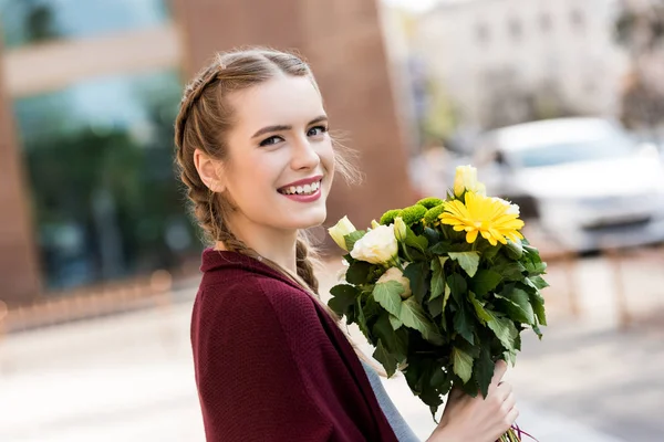 Femme heureuse avec bouquet de fleurs — Photo de stock