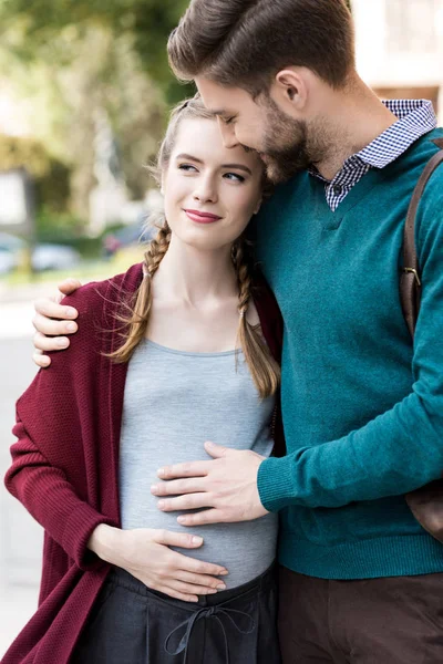Homme étreignant femme enceinte — Photo de stock