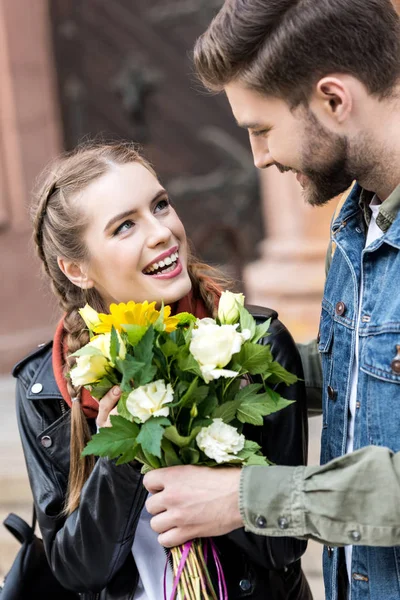 Uomo che presenta mazzo di fiori alla fidanzata — Foto stock