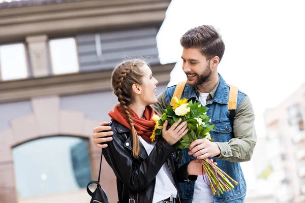 Man presenting bouquet of flowers to girlfriend — Stock Photo