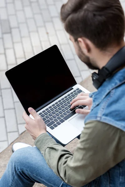 Man using laptop on street — Stock Photo