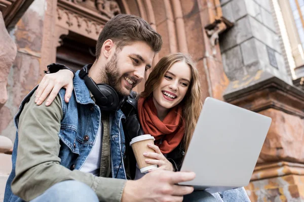 Couple using laptop on street — Stock Photo