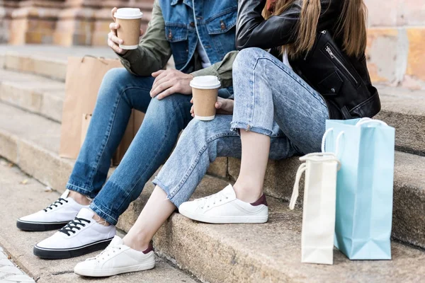 Pareja con bolsas de compras y café para llevar - foto de stock