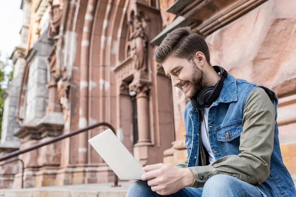 Man using laptop on street — Stock Photo