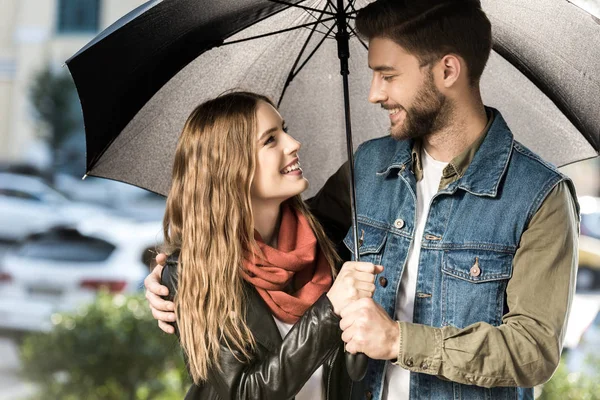 Pareja de pie bajo paraguas - foto de stock