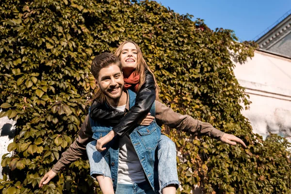 Couple piggybacking in autumn park — Stock Photo