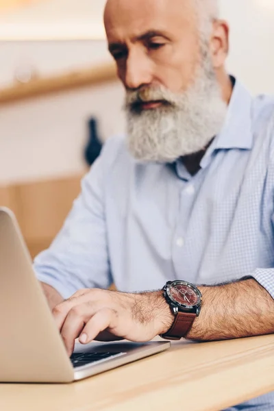 Homem sênior com laptop no café — Fotografia de Stock