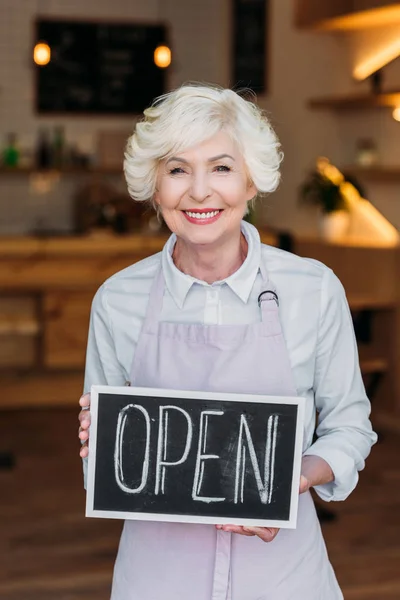 Senior worker with open chalkboard — Stock Photo