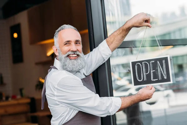 Senior worker with open chalkboard — Stock Photo