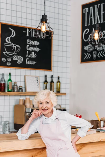 Travailleur âgé souriant au comptoir — Photo de stock