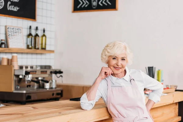 Travailleur âgé souriant au comptoir — Photo de stock