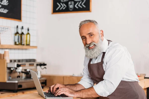 Senior worker using laptop — Stock Photo