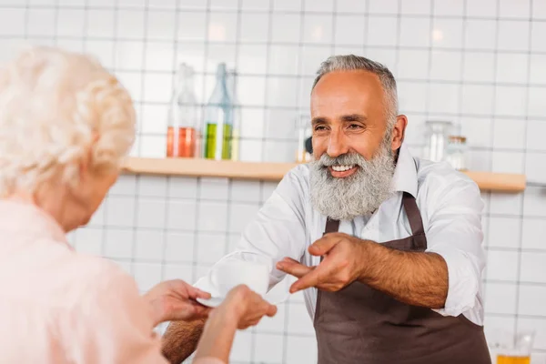 Senior barista serving coffee — Stock Photo