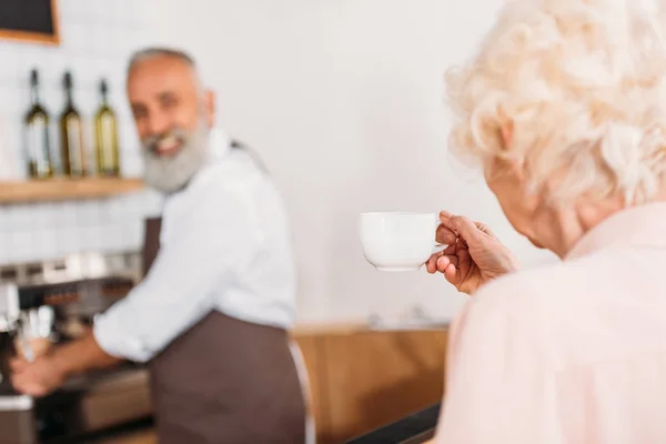 Visitor with cup of coffee in cafe — Stock Photo