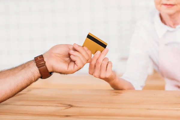 Visiteur donnant carte de crédit au travailleur du café — Photo de stock