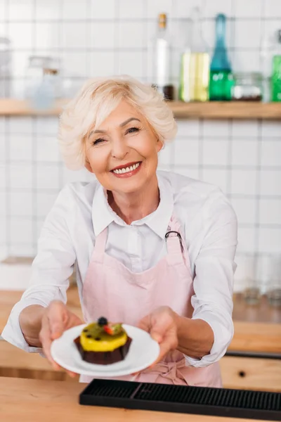 Coffee shop worker with dessert — Stock Photo
