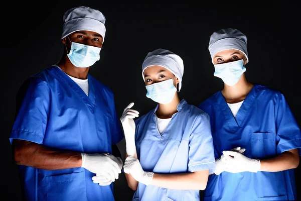 Cirurgiões multiétnicos em máscaras médicas — Fotografia de Stock