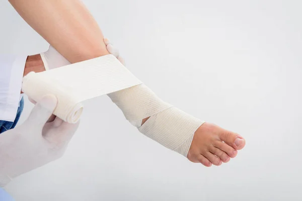 Médecin mise bandage sur la jambe — Photo de stock