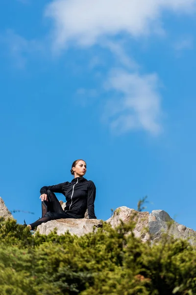 Donna seduta sulle rocce — Foto stock