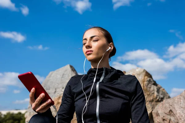 Mulher ouvindo música ao ar livre — Fotografia de Stock