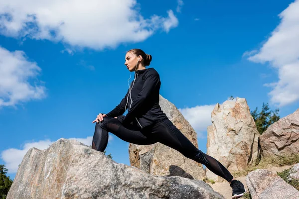 Frau streckt Beine auf Felsen — Stockfoto