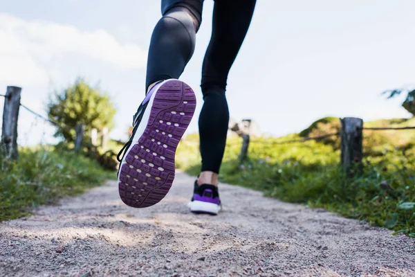 Woman jogging on rural road — Stock Photo