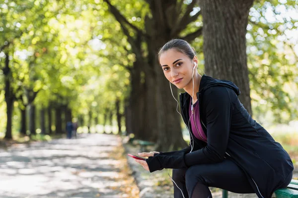 Woman listening music in park — Stock Photo