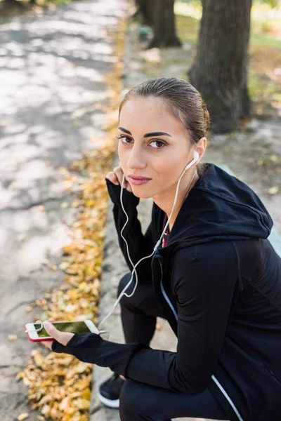 Woman listening music in park — Stock Photo