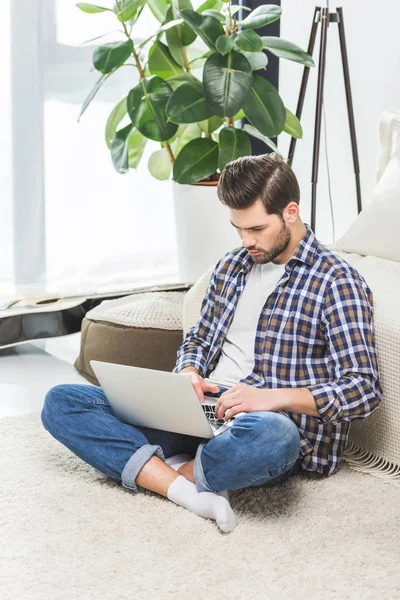 Homme utilisant un ordinateur portable à la maison — Photo de stock