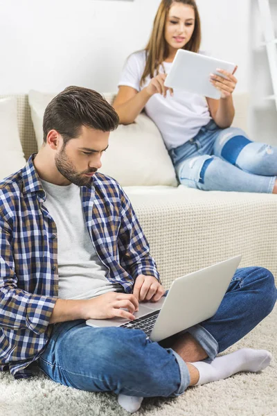 Casal usando gadgets em casa — Fotografia de Stock