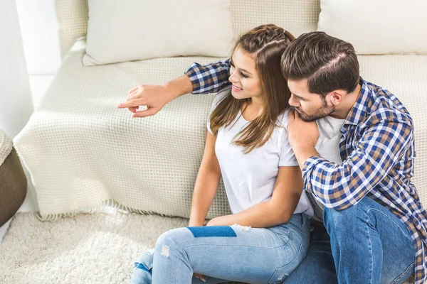 Jeune couple assis sur le sol à la maison — Photo de stock