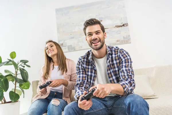 Couple playing videogame with gamepads — Stock Photo