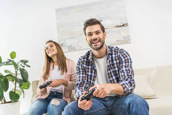 Couple jouant au jeu vidéo avec des manettes — Photo de stock