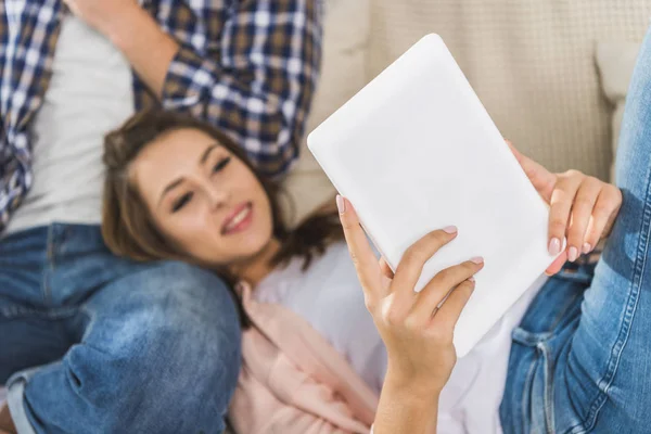 Woman using digital tablet on sofa — Stock Photo