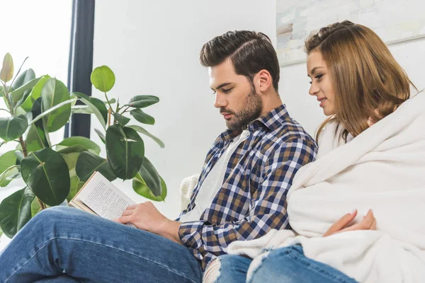 Attractive couple reading book — Stock Photo