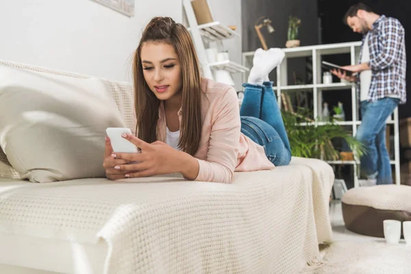Woman on sofa with smartphone — Stock Photo