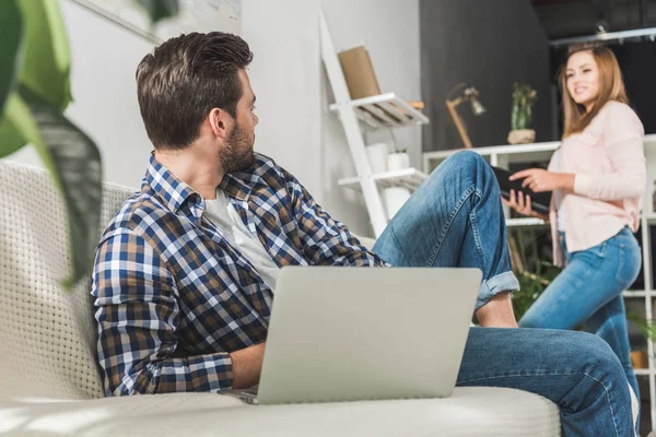 Uomo sul divano con computer portatile — Foto stock