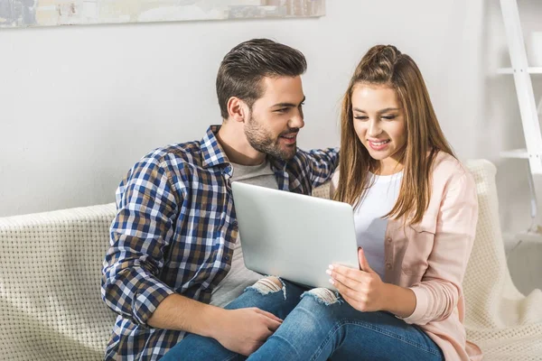 Attractive couple using laptop — Stock Photo