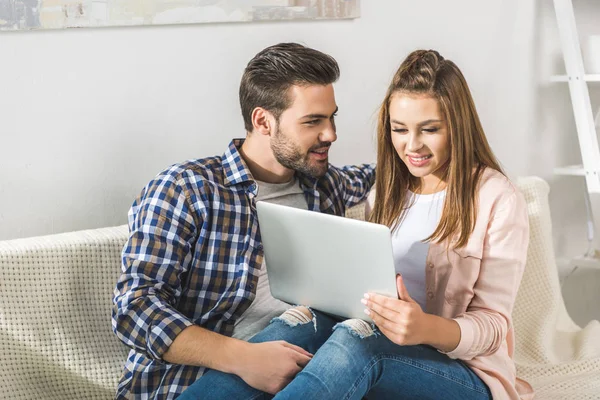 Atractiva pareja usando laptop - foto de stock