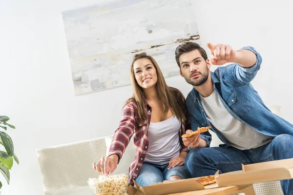 Couple watching tv with snacks — Stock Photo