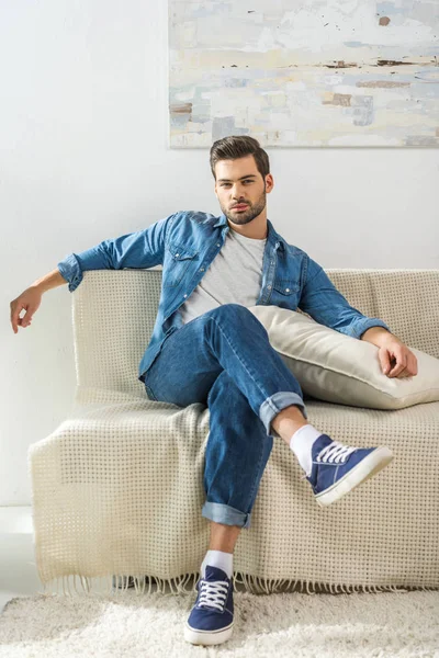 Attraktiver Mann sitzt auf Sofa — Stockfoto